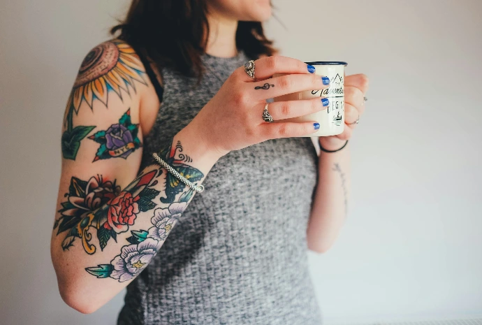 woman holding white ceramic mug